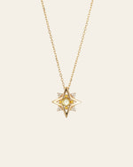 The CAMELLIA New York Peridot Pentagram Necklace is a gold piece featuring a star-shaped pendant with a central peridot gemstone and diamonds, set against a light background.
