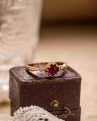 "Romantic vintage garnet ring displayed with floral decor, perfect for engagement"